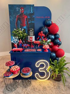 a spiderman themed birthday party with balloons and decorations