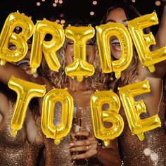 two women in gold dresses holding up balloons that say bride to be and the words bride to be