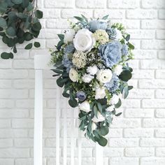 a bridal bouquet sitting on top of a white chair next to a brick wall