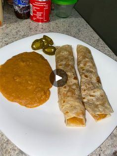 a white plate topped with food next to pickles and sauce on top of a counter