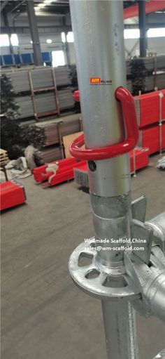 an image of a metal pole in the middle of a warehouse building with red seats