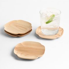 three wooden coasters sitting on top of each other next to a glass filled with water