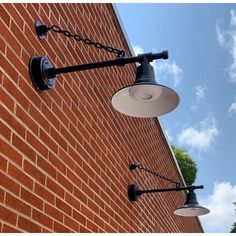 two lights are attached to the side of a brick building