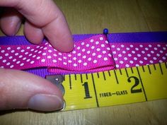 someone is measuring the length of a pink and white polka dot ribbon