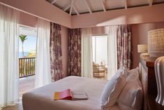 a bed sitting in a bedroom next to a window with curtains on top of it