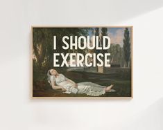 a woman laying on the ground in front of a painting that says, i should exercise