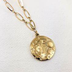 Our celestial-inspired necklace set features two intricately crafted pieces adorned with a beautifully engraved scene of the moon, stars, and sun. Crafted from stainless steel and plated in 18k gold, this 2 in one necklace offers a modern layered look. Embrace celestial charm with these versatile piece or layer together with more necklaces for a truly bold statement. Material: Stainless Steel - 18k Gold plated Size: can be extended to approx. 17 in. Weight: 4 oz Silver Sun And Moon Design Gold-plated Necklace, Celestial Metal Necklace With Moon Charm, Celestial Brass Necklace With Adjustable Chain, Adjustable Celestial Engraved Jewelry, Celestial Pendant Charm Necklace With Adjustable Chain, Celestial Crescent Charm Necklaces With Adjustable Chain, Celestial Yellow Gold Charm Necklaces With Moon Phase, Celestial Yellow Gold Moon Phase Charm Necklaces, Celestial Moon-shaped Metal Necklaces