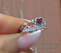 Crown Garnet red Heart Cubic Zirconia SOLID sterling stamped 925 silver Tarnish free sizes 5-11 Some sizes are sold out. But will be replenished shortly Top of ring is 8.3mm. Band width is 2.3 and shank is 2mm The Red CZ center stone is .3ct 4.5mm Round stone Number of clear CZ's are 16 This is set in a Bezel setting Nothing but the best from my custom jewelry store. Email me if you have any questions. Red Heart Ring, Barbie Ring, Promise Ring Silver, Crown Engagement Ring, Crown Ring Princess, Ring Luxury, Engagement Rings For Women, Colored Engagement Rings, Silver Jewelry Design