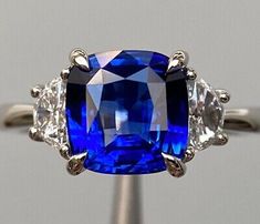 a blue and white stone ring with three diamonds