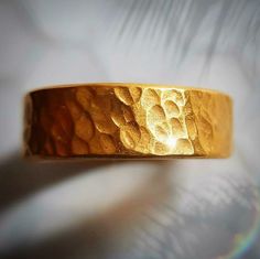 This is a thick and hefty solid 24k gold band with a hammered finish. The ring is approximately 6 MM wide. 24k gold is relatively soft, but the thickness and irregular handmade finish makes this ring wearable. This is a serious chunk of gold, and the color of real 24k gold really has no match, it is absolutely beautiful. Even if you look for one, there are not many rings available like this. The size is an 9, but I can make it any size. Also, I can make this in 22k gold, which is slightly more d Gold Hammered Bands For Promise Ring, Handmade Gold Rings With Thick Band, Handmade Gold Rings For Marriage, Gold Hammered Wide Band Ring For Anniversary, Gold Thick Band With Adjustable Fit, Gold Adjustable Thick Band, Adjustable Gold Wide Band Wedding Ring, Adjustable Gold Wide Band Ring For Wedding, Adjustable Thick Gold Band