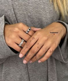 a woman's hand with two rings on it