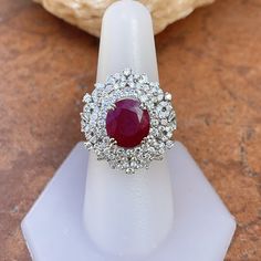 18KT White Gold Oval Ruby + Pave Diamond ring Size 8 Can be resized for an additional fee Large Statement Ring Lovely intricate design This an absolutely lovely attention getting piece! Round and Baguette Diamonds with Oval Faceted Ruby Ring. Approx 4.83 CT Ruby 10.7 x 9.9x 5.7 mm 2.20 CT Diamond Approx 9.8 grams 18KT Stamped Abrasions to the Ruby, which could be polished out by a stone cutter. We can quote for that if need b3, but this ring is so pretty, it really does not need. Check out all o White Oval Ruby Ring, Oval White Ruby Ring, Elegant White Oval Ruby Ring, Gia Certified Fine Jewelry Ruby Ring, Gia Certified Ruby Ring For Wedding, Ballerina Ring, Saint Jewelry, Anniversary Wedding Band, Pave Diamond Ring