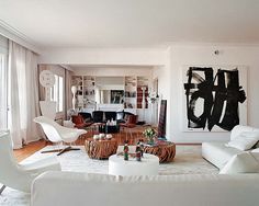 a living room filled with white furniture and lots of windows