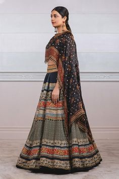 Black chanderi lehenga with geometric and floral printed motifs. Paired with printed cape attached blouse.
Component: 2
Printed
Neckline: Round
Sleeve Length: Three quarter
Fabric: Lehenga: Chanderi, Blouse: Silk
Color: Black
Tassel border
Attached cape - Aza Fashions Black Designer Wear Sets With Motifs, Chanderi Sets With Motifs For Reception, Black Palazzo Set For Eid Reception, Black Palazzo Set For Reception During Eid, Black Bollywood Palazzo Set For Reception, Traditional Black Palazzo Set For Reception, Bollywood Black Palazzo Set For Reception, Black Diwali Choli With Motifs, Black Designer Lehenga For Transitional Season