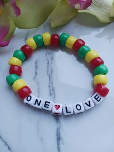 "Perfect for fans of Bob Marley, and just in time for the release of the biopic \"One Love\".  This is handmade at the time of order and is made using high-quality stretchy cord and beads. However, they are delicate, and I recommend you do not wear while sleeping, swimming, bathing, or working out.   One size fits most makes for easy gift giving. Standard bracelet size is 7 inches. If you need a custom size, please message me. Please measure your wrist before ordering. I am happy to do any size Friendship Beaded Bracelets With Letter Beads, Colorful Plastic Beaded Bracelets As Gift, Colorful Plastic Beads For Gifts, Plastic Stretch Bracelet With Round Beads For Gift, Red Plastic Beaded Bracelets As Gift, Plastic Stretch Bracelet With Round Beads As Gift, Colorful Beaded Stretch Bracelet Perfect For Gifts, Plastic Letter Beads Bracelets As Gift, Beaded Themed Stretch Bracelet For Friendship