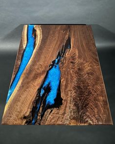 a piece of wood that has blue paint on it and is sitting on top of a table