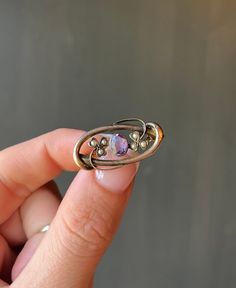 "* Antique Art Deco era (late 1920's - 1930's) handmade 9 carat rose gold brooch, set with a faceted ameythst cabochon in the center, and shamrock clover detailing, each set with three natural seed pearls.  * Stamped \"9CT\" on the back of the brooch  * Measurements- 1.2 inches long x 0.6 inch wide  * Weight- 2.8 grams  Please view and inspect the photos closely, as they are considered part of the condition. I endeavor to fully disclose all condition information clearly, however, please note that what qualifies as excellent condition for historical jewelry / collectibles differs from modern and contemporary pieces. Minor age wear is typical and to be expected for antique and vintage jewelry. All items are unpolished and in their vintage condition, items can easily be polished up if so desi Heirloom Oval Gemstone Brooches, Antique Oval Gemstone Brooch, Antique Oval Gemstone Brooches, Art Deco Oval Brooch For Anniversary, Oval Gemstone Brooches For Anniversary, Collectible Art Nouveau Hallmarked Brooch, Vintage Purple Oval Brooch, Elegant Sterling Silver Brooch With Cabochon, Antique Hallmarked Purple Brooches