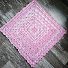 pink and white crocheted placemat on wood floor