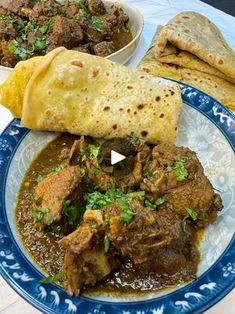 a blue and white plate topped with food next to a bowl of meatballs, tortillas and pita bread