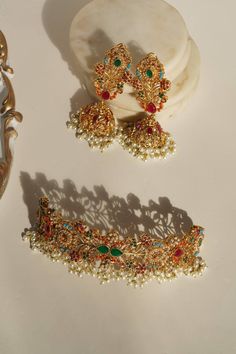 Le « Chaya - Collier ras du cou et boucles d'oreilles Jhumka » est un chef-d'œuvre royal et intemporel. Cet ensemble incarne l'équilibre délicat entre le charme des pierres multicolores et la simplicité du design moderne, créant une pièce séduisante qui fait appel à l'esthétique moderne.

 Chaque pièce de cet ensemble est conçue pour faire une impression durable. L'ensemble comprend un collier ras du cou et une paire de superbes boucles d'oreilles Jhumka superbement ornées de diverses pierres. Multicolor Temple Jewelry Bridal Earrings With Intricate Design, Multicolor Bridal Earrings With Intricate Design For Diwali, Multicolor Intricate Bridal Earrings For Diwali, Multicolor Chandbalis With Intricate Temple Design, Elegant Multicolor Ceremonial Jewelry, Multicolor Bollywood Bridal Earrings With Intricate Design, Gold Plated Chandbali Jewelry For Navratri, Multicolor Hand Set Temple Jewelry Sets, Multicolor Hand-set Jewelry For Ceremonial Occasions