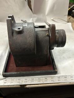 an old camera sitting on top of a piece of paper next to a measuring ruler