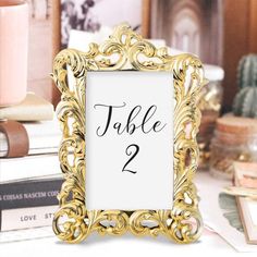 a table number frame sitting on top of a table next to some books and candles