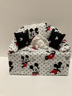 a mickey mouse chair with some black and white pillows