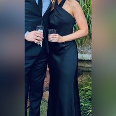 a man and woman standing next to each other in formal wear posing for the camera