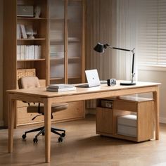 a wooden desk with a laptop computer on top of it next to a chair and bookcase