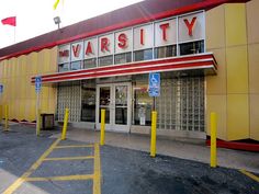 an empty parking lot in front of a building with yellow and red stripes on it