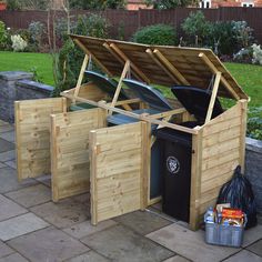 three wooden trash cans are outside in the yard