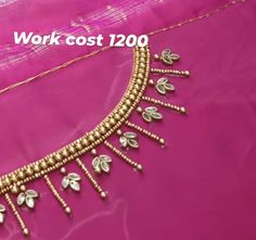 the work cost 1200 is being displayed on a pink cloth with gold beads and leaves