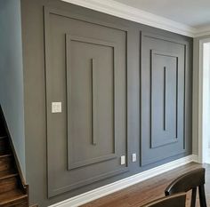 an empty room with gray walls and wooden floors