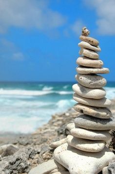 a stack of rocks sitting on top of a sandy beach