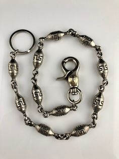 "Here we have a stunning Gianni Versace Medusa wallet chain that features a greek key pattern! This high-quality chain will be an eye-catching feature on your wallet. This piece measures in at 23 1/4 inches in length and weighs in at 7.1 ounces. Keep this accessory for your own closet or perhaps give it away as a gift to someone special!  23 1/4 inches in length 7.1 ounces * Please Note: These items are secondhand, vintage, rare and/or antique and may show some signs of previous ownership. Pleas Greek Key Pattern, Greek Key, Gianni Versace, Wallet Chain, Infinity Bracelet, Purse Wallet, Versace, Personalized Items, Wallet