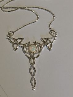 "I've fabricated a Celtic Knot inspired, statement necklace to which is perfect for a wedding, or hand fasting, or even a Renaissance event, with sterling silver Trinity Knots woven into a necklace and featuring an 8mm glowing genuine White Moonstone, or your choice from the drop down menu. The motif of the pendant is designed with a total of 5 Trinity Knots and sterling wire work braids down the center to add the balancing touches to the piece. It comes with a 16 inch sterling silver box chain Spiritual Jeweled Wedding Necklace, Bohemian Clavicle Chain Jewelry For Wedding, Elegant Moonstone Jewelry For Festivals, Bohemian Wedding Necklace With Jewels, Bohemian Necklace With Adjustable Chain For Wedding, Bohemian Wedding Necklace With Adjustable Chain, Mystical Handmade Necklace For Wedding, Handmade Mystical Necklace For Wedding, Spiritual Handmade Necklaces For Wedding