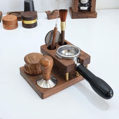 an assortment of wood and metal items on a white counter top with wooden spoons