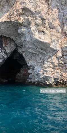 the entrance to an ocean cave with blue water