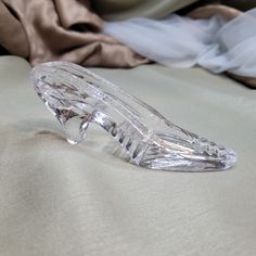 a clear shoe sitting on top of a bed