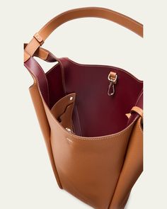 Tod's bucket bag in grained calf leather     Fixed top handles, 12.6" drop     Hook closure     Removable pendant with branded metal T Timeless accessory    Interior, two slip pockets     Lining: Leather/nylon/polyurethane    Approx. 12.6"W x H 11.8"H x 4.7"D    Made in Italy Cognac Bucket Bag With Handle Drop, Cognac Epsom Leather Bag With Palladium Hardware, Designer Tan Bucket Bag For Everyday, Timeless Bucket Bag With Leather Handles, Timeless Leather Handled Tote Bucket Bag, Timeless Leather-handled Tote Bucket Bag, Tan Satchel Bucket Bag With Detachable Handle, Timeless Tote Bucket Bag With Leather Handles, Luxury Tan Bucket Bag With Double Handle