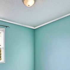 an empty room with blue walls and white trim