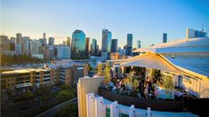 people are gathered on the roof of a building in front of a cityscape