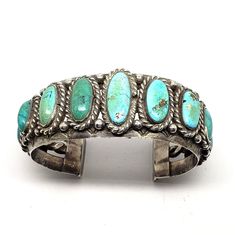 Tribal Affiliation: Navajo Artisan: unknown Provenance: Ownership History Available Country/Region of Manufacture: United States Heavy Authentic Vintage Navajo Turquoise Cuff Bracelet.  Top width is 1-1/8", interior circumference including the wrist opening is 7".  Wrist opening is 1-1/4". This antique Vintage silver Navajo Turquoise Cuff Bracelet is Circa 1940-50's's.  The beautiful unstabilized turquoise stones exhibit an array of hues and colors due to its age. This cuff is made with a heavy gauge of silver. It weighs over 3-1/2 ounces or 106 grams.  It is unsigned, which was common for its era.  Due to the thickness of the silver this bracelet would NOT easily be adjusted smaller or larger.  There are no chips or cracks in the stones. We have had the fortune over the years of being abl Vintage Turquoise Bangle Cuff Bracelet, Antique Turquoise Adjustable Bracelet, Antique Turquoise Bangle Cuff Bracelet, Antique Adjustable Turquoise Bracelet, Handmade Turquoise Vintage Cuff Bracelet, Adjustable Turquoise Vintage Cuff Bracelet, Adjustable Vintage Turquoise Cuff Bracelet, Collectible Bohemian Turquoise Bracelets, Collectible Bohemian Turquoise Bracelet