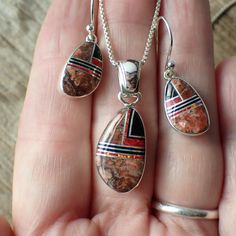 This stunning sterling silver set is created and stamped by Navajo artist Sheryl Martinez. It features an inlay design of Wild Horse, Jet & Opal. The earrings measure 1.2" long including the ear wire by 0.4" wide. The pendant measures 1.3" long (from the top of the bail) by 0.5" wide.Pictured on a 1 mm chain which is sold separately here. Red Sterling Silver Jewelry With Polished Finish, Southwestern Style Jewelry In Sterling Silver, Southwestern Style Jewelry In Sterling Silver Stamped 925, Southwestern Sterling Silver Jewelry Stamped 925, Red Southwestern Style Collectible Jewelry, Southwestern Sterling Silver Gemstone Jewelry, Southwestern Silver Jewelry With Inlay, Red Sterling Silver Jewelry With Inlay, Southwestern Jewelry With Inlay For Gifts