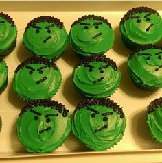 there are many green cupcakes that have faces on them and eyes drawn on them