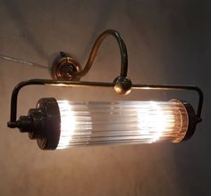 a light that is on the side of a wall next to a lamp shade and some wires