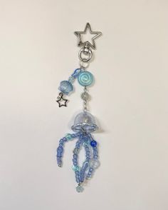 a keychain with beads and charms hanging from it's side on a white surface