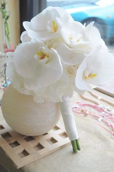 white flowers are in a vase on a table