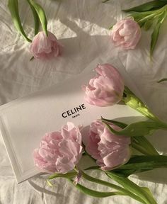 pink flowers are laying on a white sheet with the name celline written in it