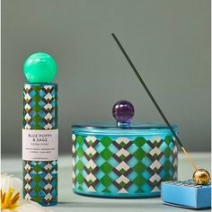 a blue box with a green top next to a candle